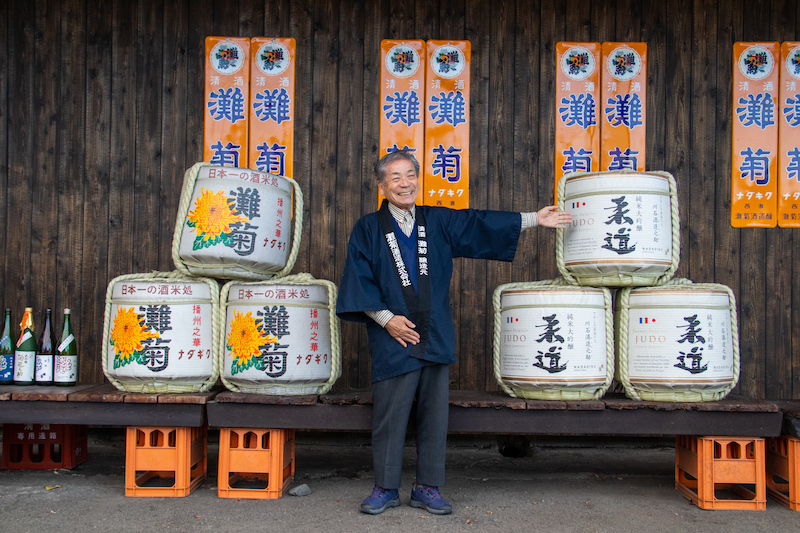 The CEO of the Nadagiku Brewery and their products in sake barrels.